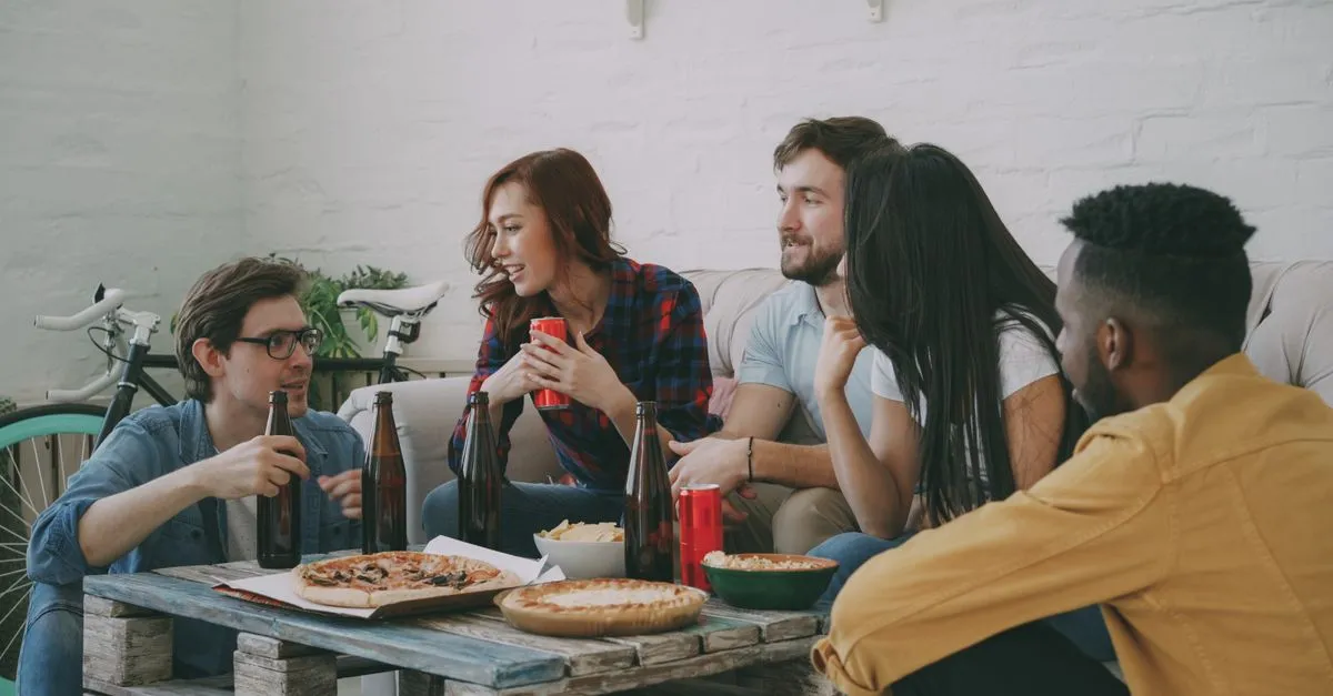 Mãos pegando fatias de pizza artesanal fresca, evidenciando a borda alveolada e crocante, ideal para festa em casa pizza.