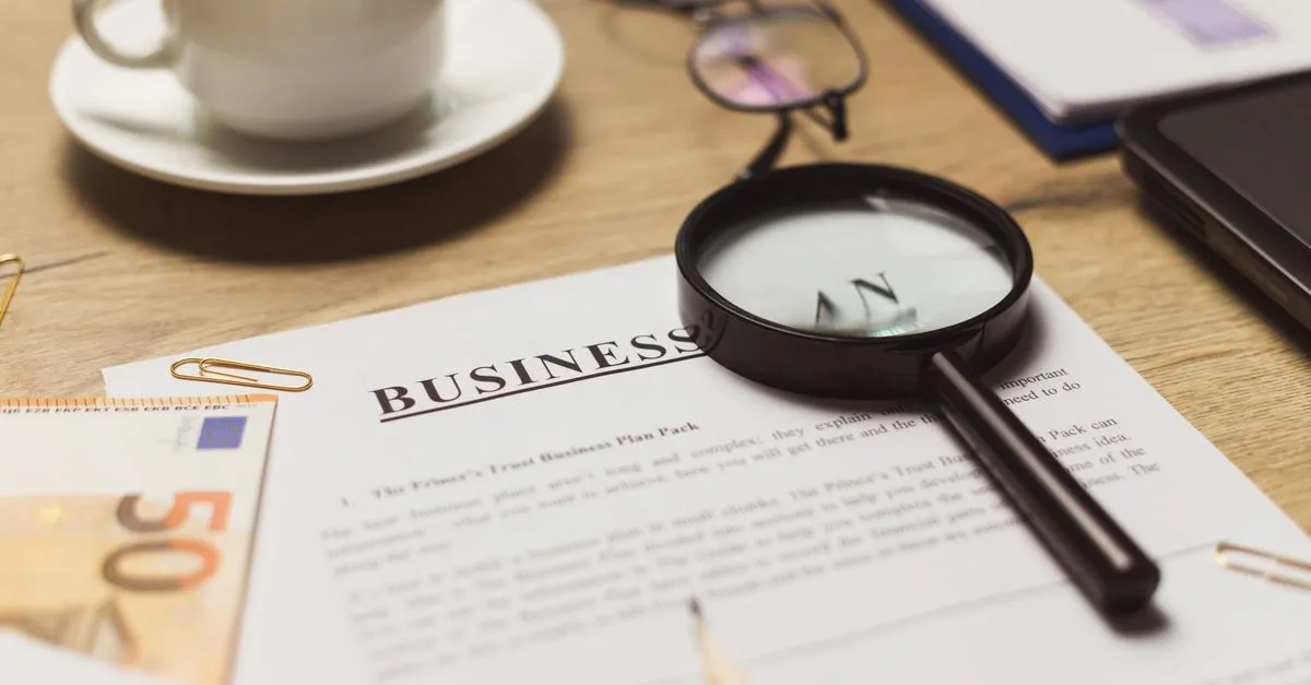 Documentos de financiamento de sala comercial e maquete de prédio, simbolizando investimento.