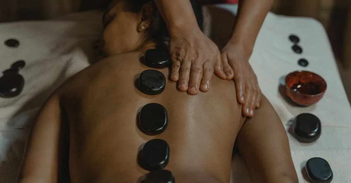 Pedras quentes em sessão de massagens terapêuticas no Kairós Spa, promovendo relaxamento muscular.
