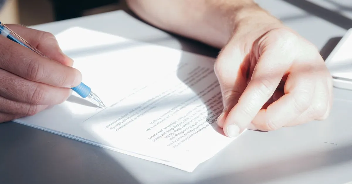 Mãos revisam contrato de financiamento de imóvel misto, destacando aspectos legais e documentação.
