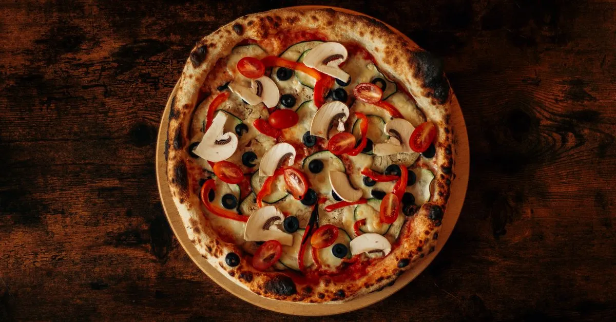 Pizza artesanal crocante com bordas alveoladas servida em animada festa em casa pizza.