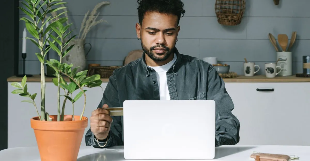 Pessoa em casa analisa opções de crédito no laptop, ponderando a troca de dívidas por soluções estruturadas.