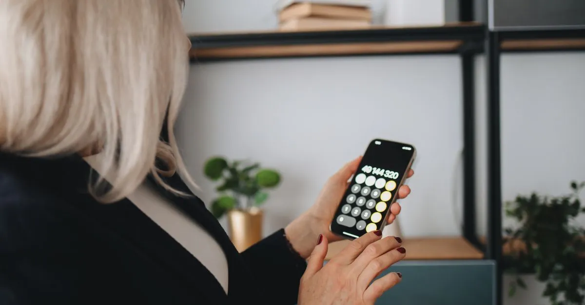 Calculadora e celular planejando a economia com energia solar por assinatura mensal.