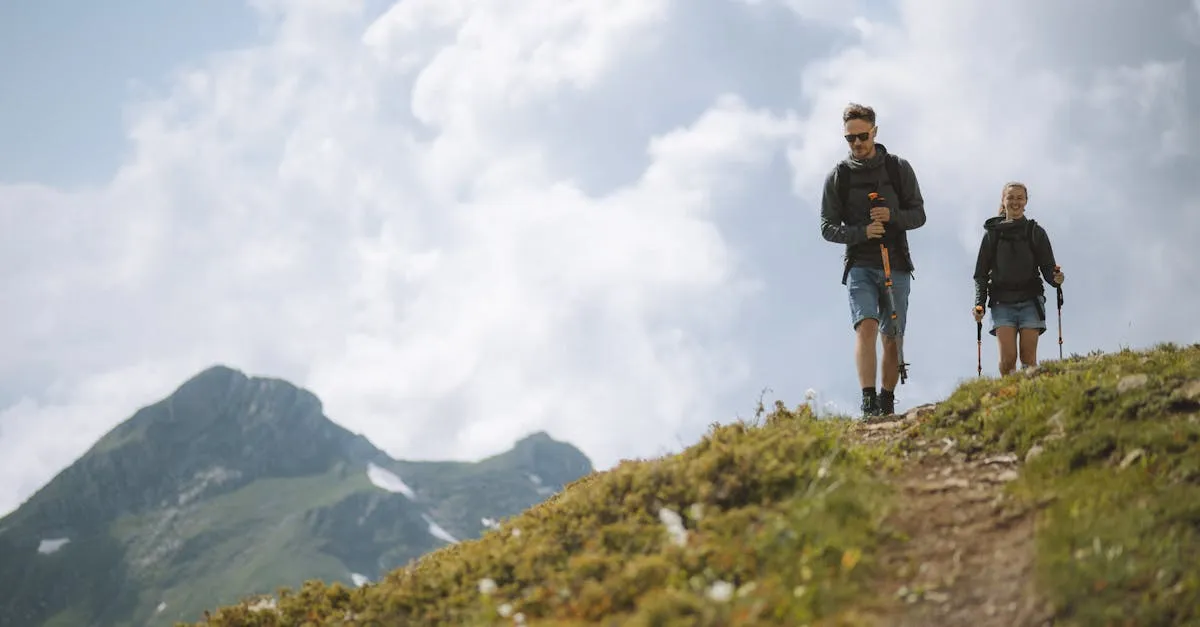Casal fazendo trilha na montanha com mochilas e bastões. Saiba como viajar com segurança e explorar a natureza com a Viagente.