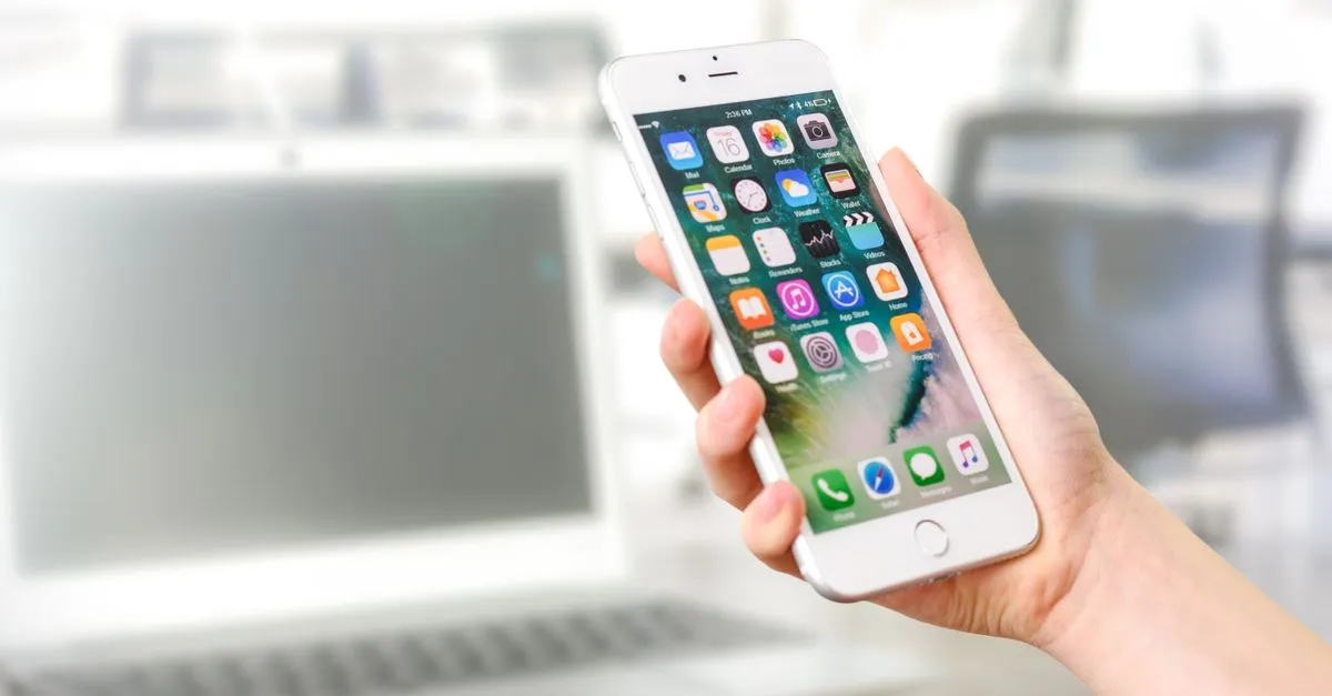 Smartphone com tela de saldo positivo após indicação de crédito bem-sucedida.