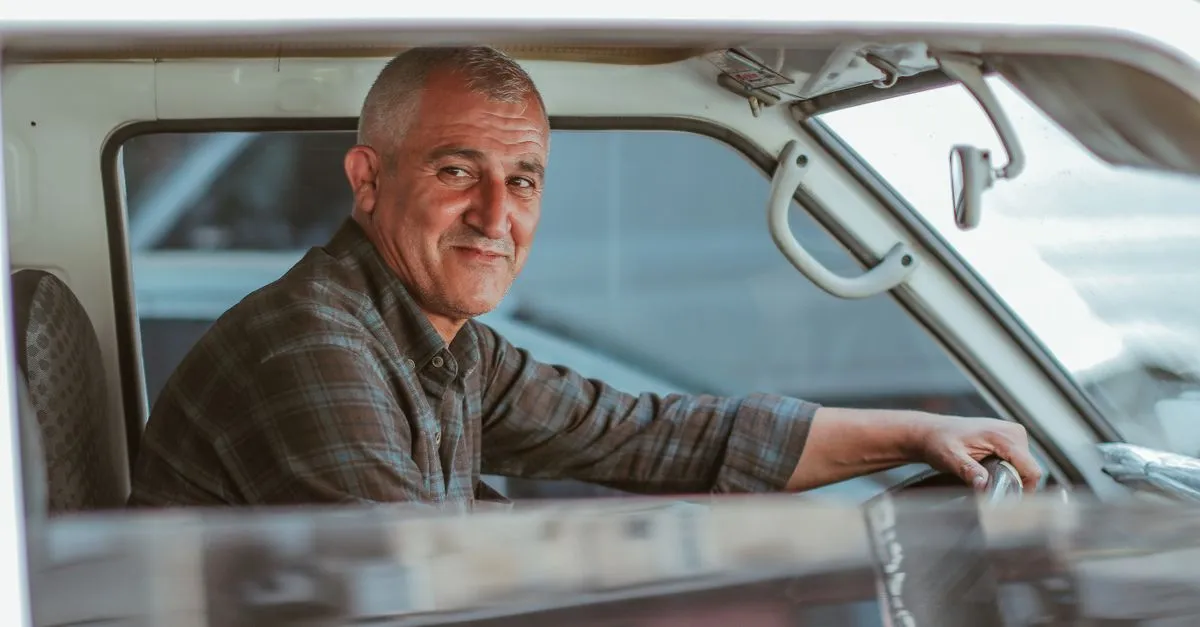 Motorista feliz ao lado do veículo após conseguir o financiamento de caminhão.