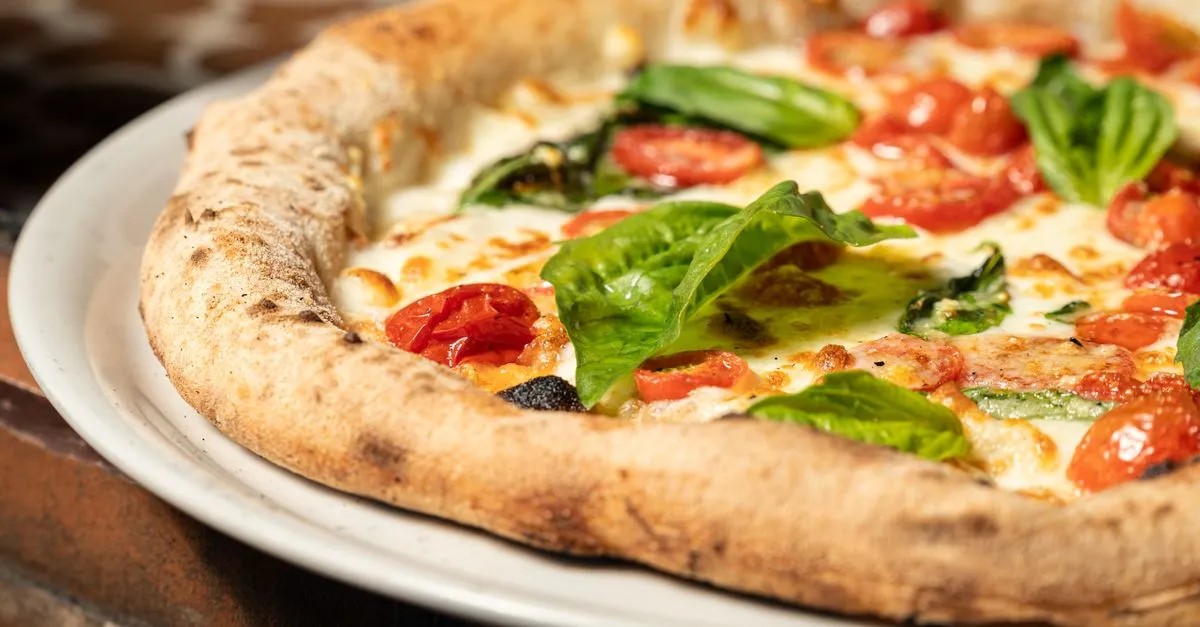 Fatia de pizza napolitana com borda alveolada e crocante, perfeita para pizza para eventos a domicílio.
