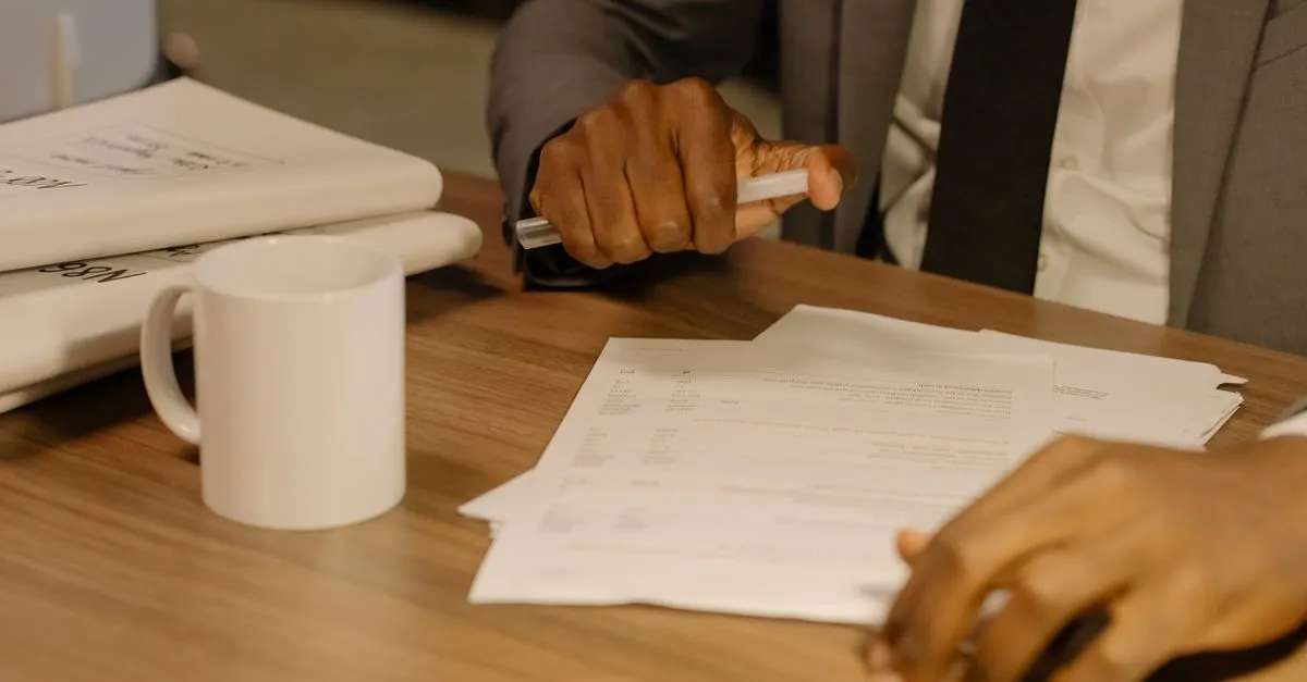 Mãos analisando documentos financeiros, planejando crédito para inventário de forma responsável e detalhada.