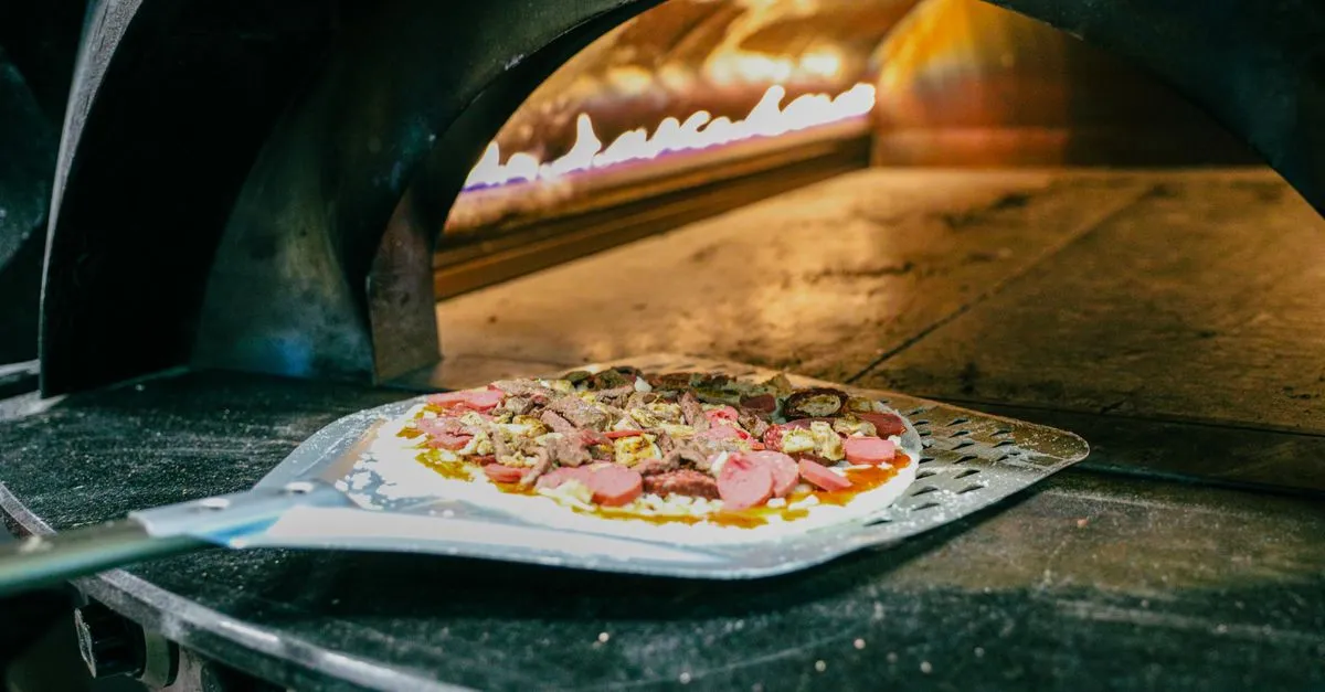 Pizzaiolo experiente assando pizza napolitana em forno portátil, garantindo pizza para festas preco e sabor artesanal.