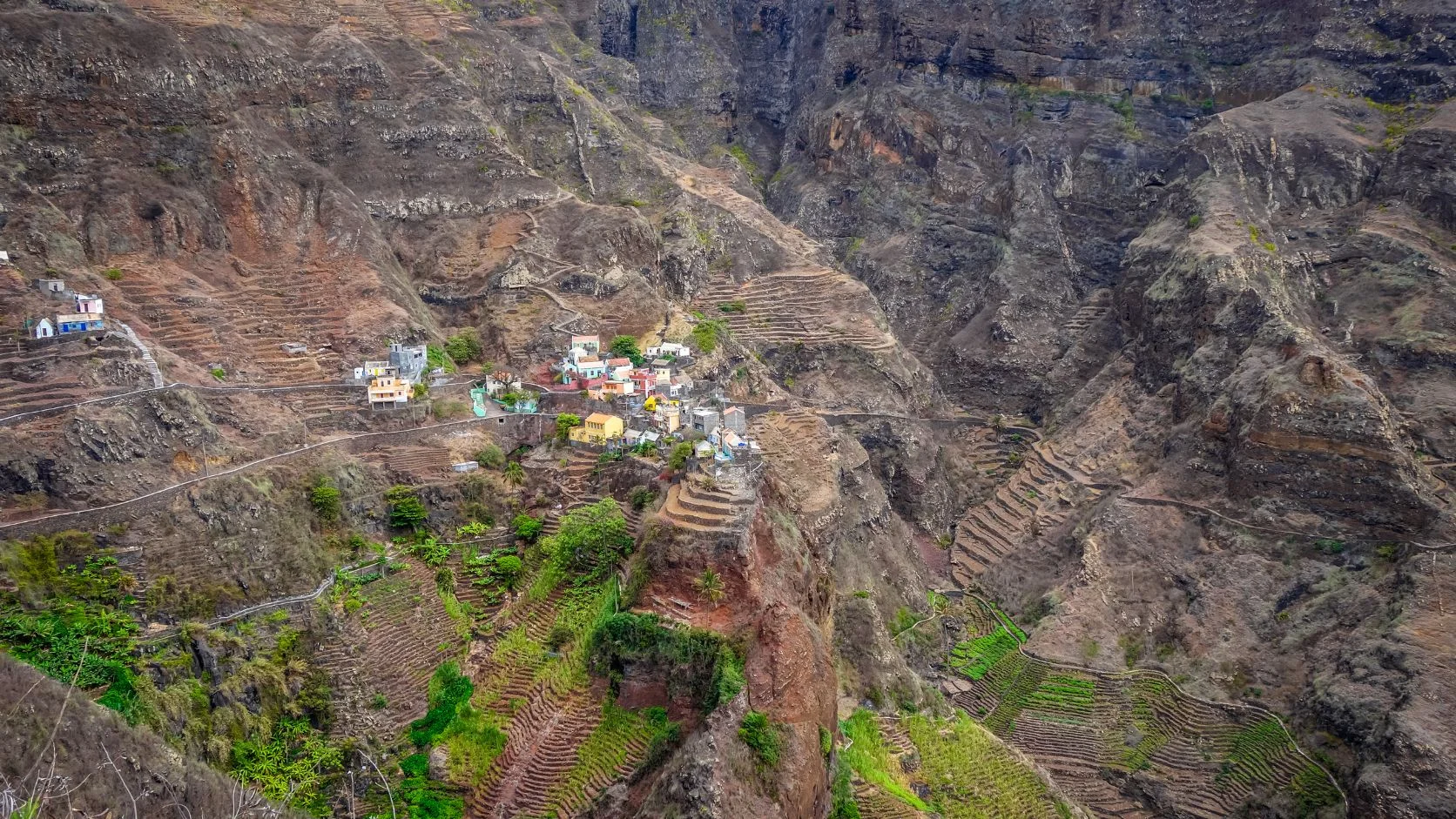 Casal explorando trilha vulcânica em Santo Antão, Cabo Verde, paisagem montanhosa. Guia de Cabo Verde.