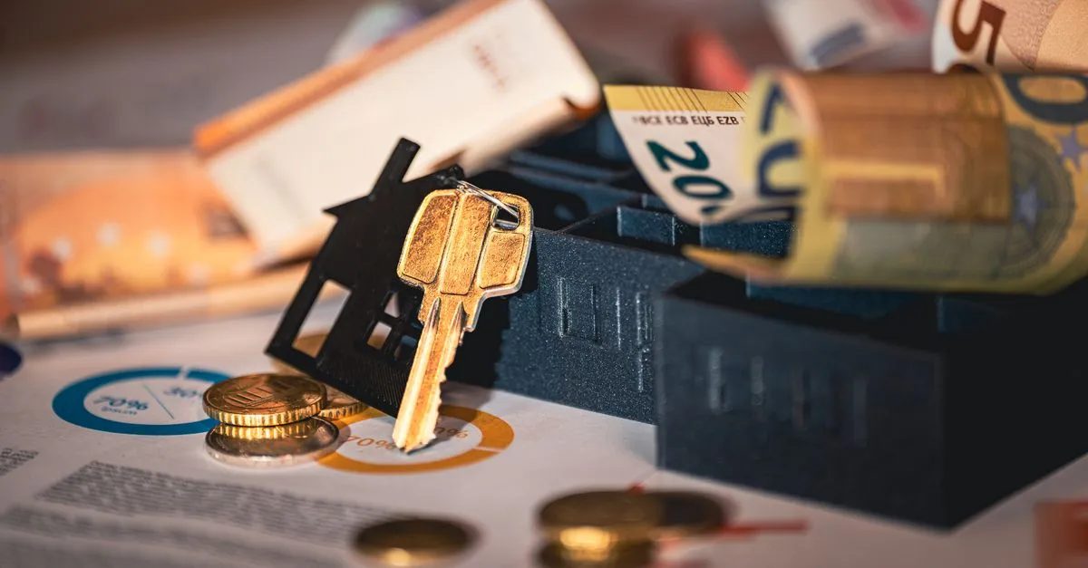 Miniatura de casa com moedas simbolizando a aquisicao de bens usando credito para investir em imoveis e patrimonio