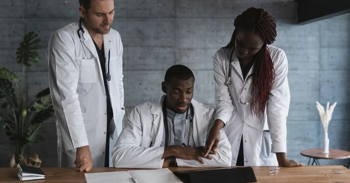 Equipe de clínica médica feliz revisa gráficos de crescimento financeiro, garantindo capital de giro.