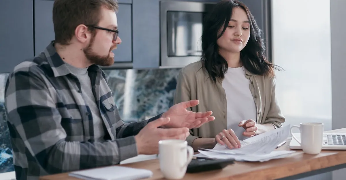 Consultora financeira explica diferencas entre home equity ou financiamento para casal em escritorio.