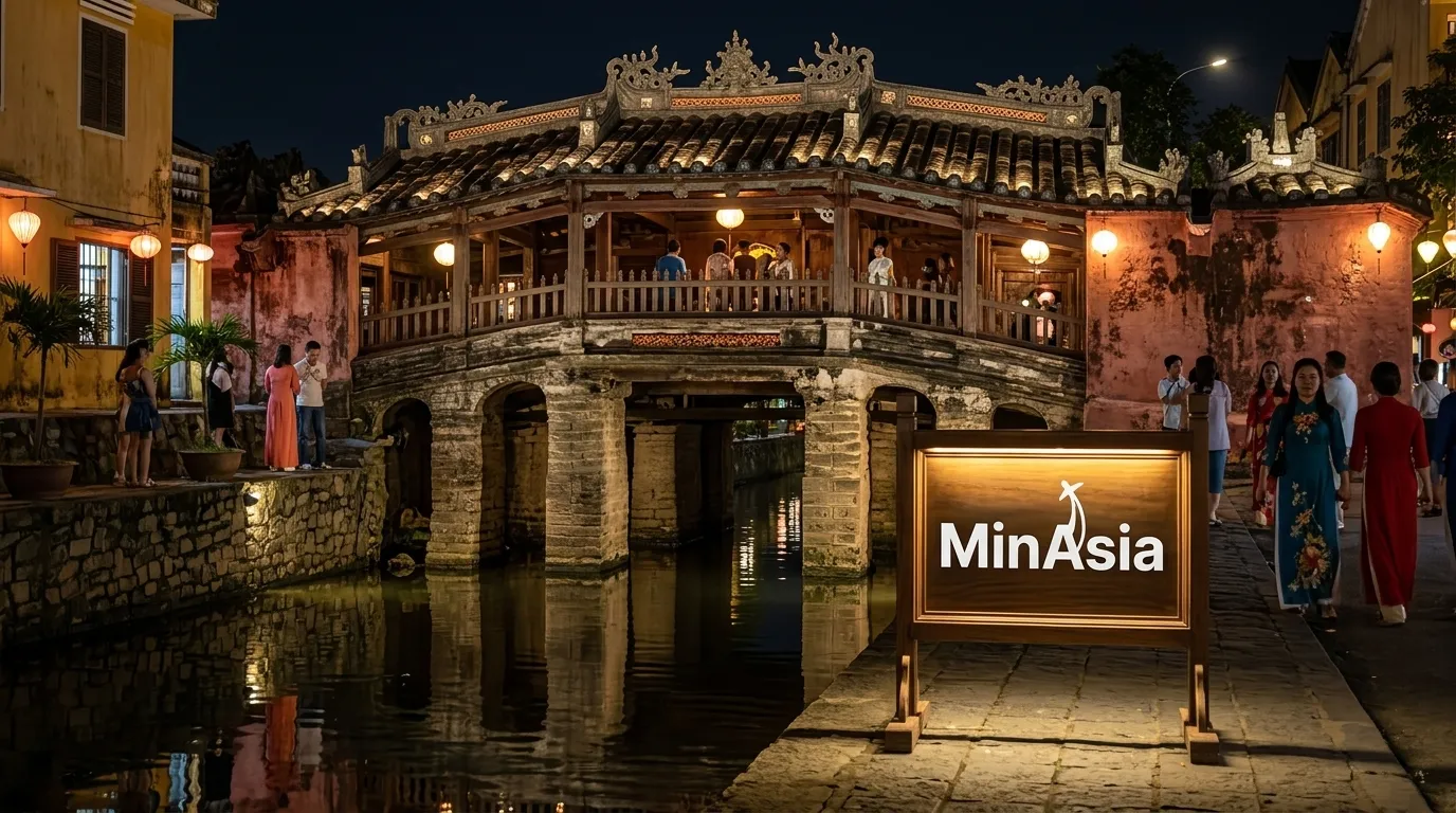 Ponte Japonesa iluminada a noite refletindo no canal em Hoi An.
