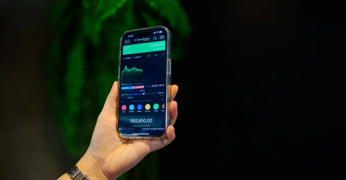 Mão analisa dados de economia em celular, destacando o retorno do financiamento de energia solar.