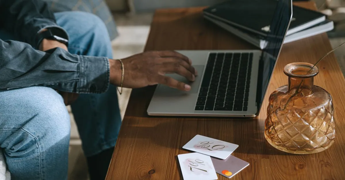 Pessoa compara opções de empréstimo para abertura de filial no laptop, com foco em decisão informada.